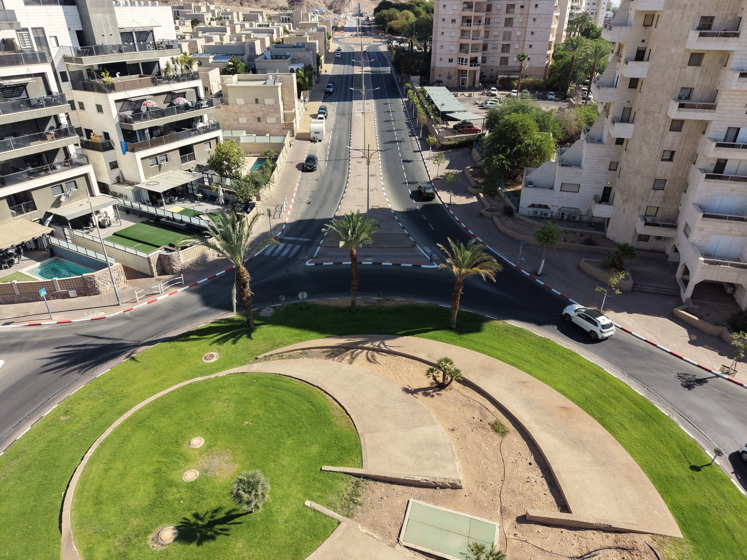 כיכר ירוקה עם דקלים ומעברי חצייה צבועים