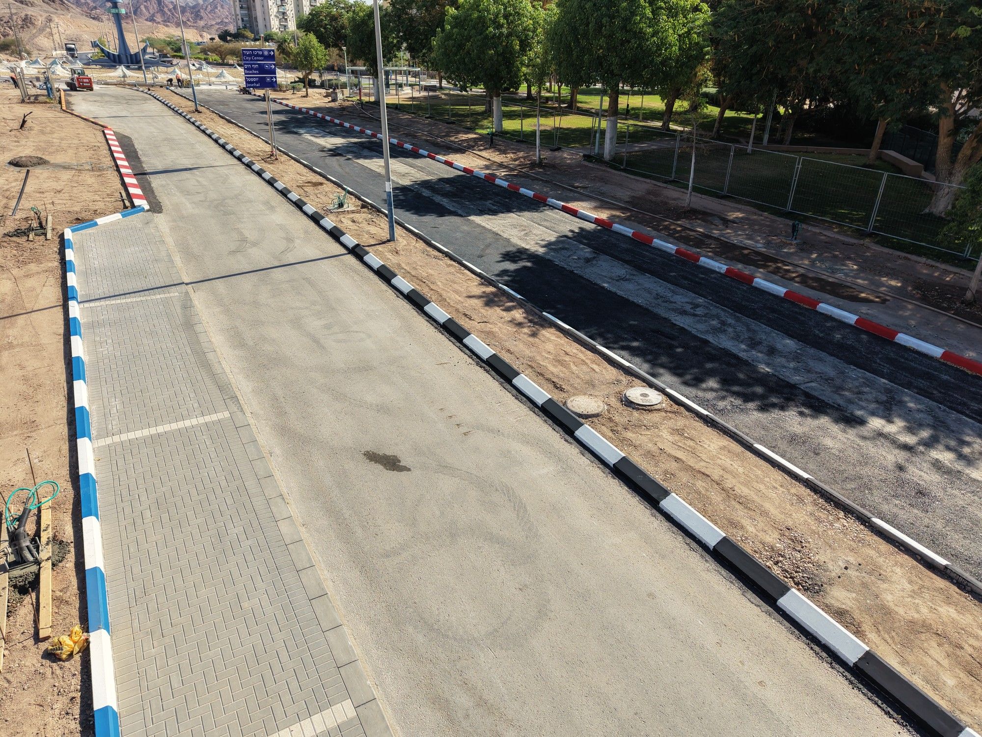 מפרץ מרוצף ואבני שפה בכחול־לבן לאורך הרחוב