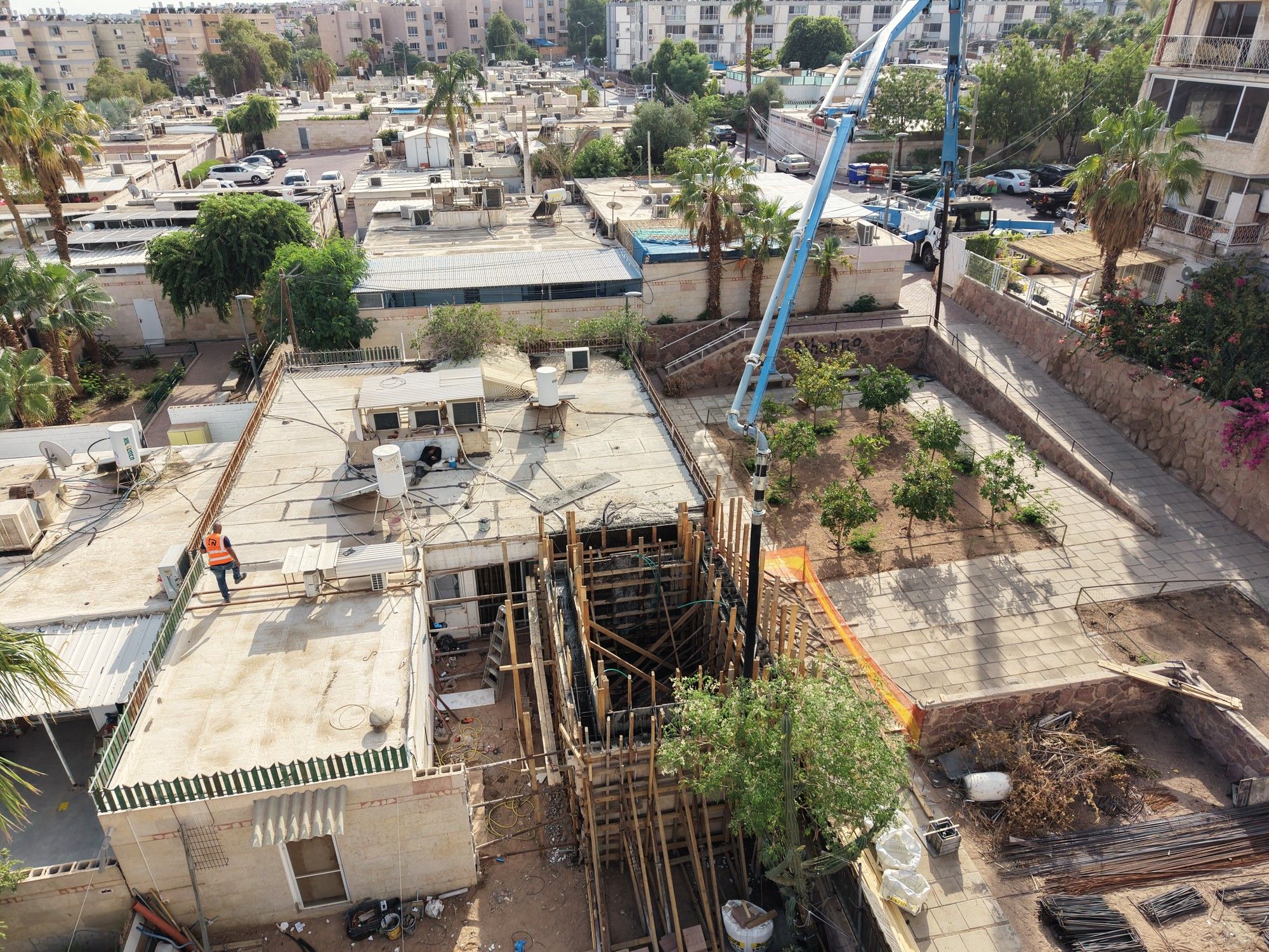זרוע משאבת הבטון מעל הטפסנות, ופועלים באתר