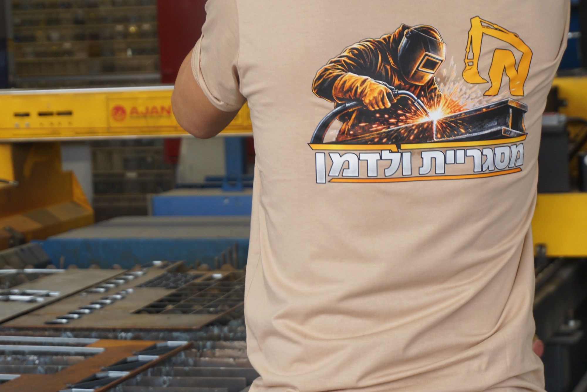 גב חולצת מסגריית ולדמן מול שולחן הפלזמה