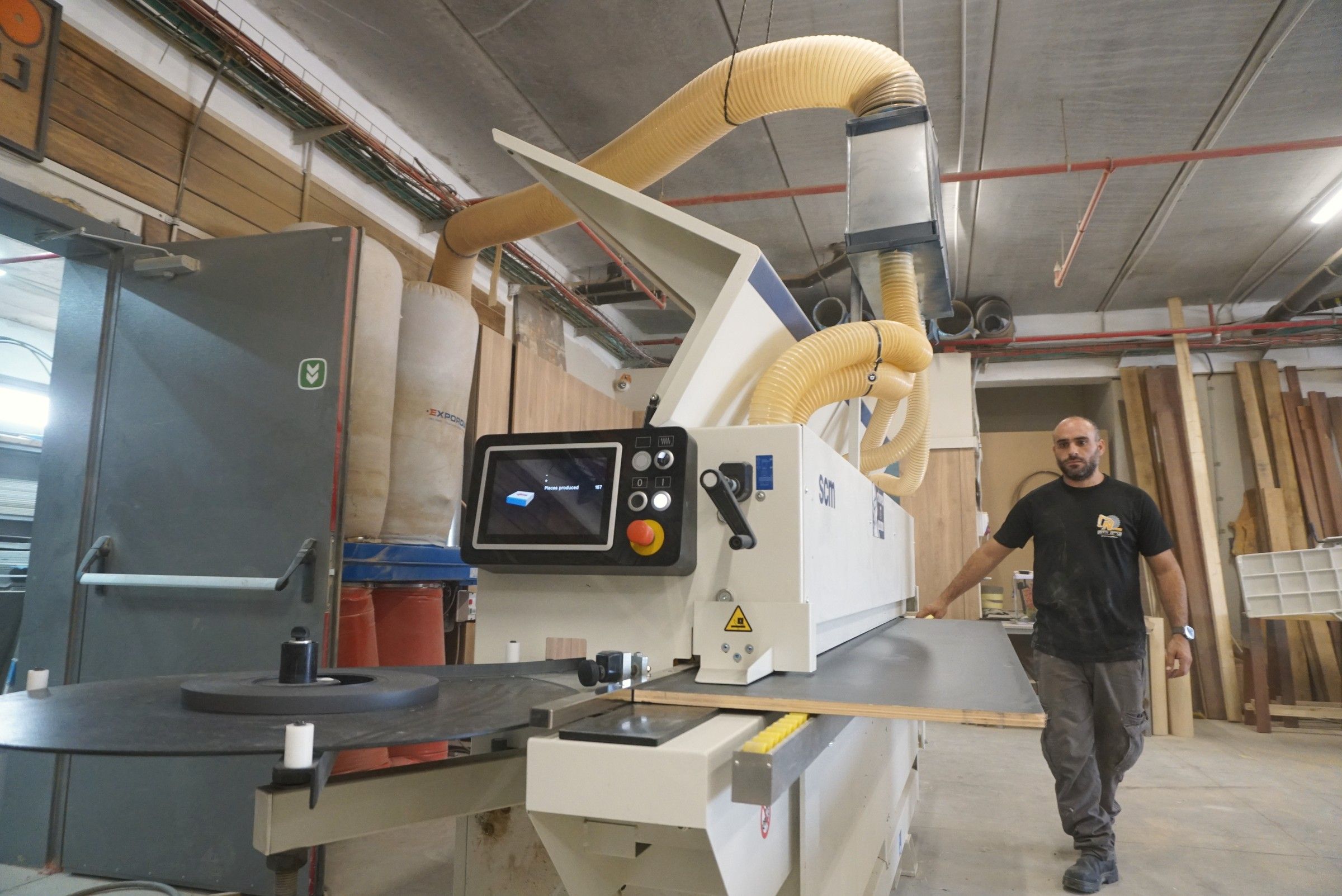 מכונת קנטים ממוחשבת באולם הנגרייה, עם צינורות יניקה צהובים