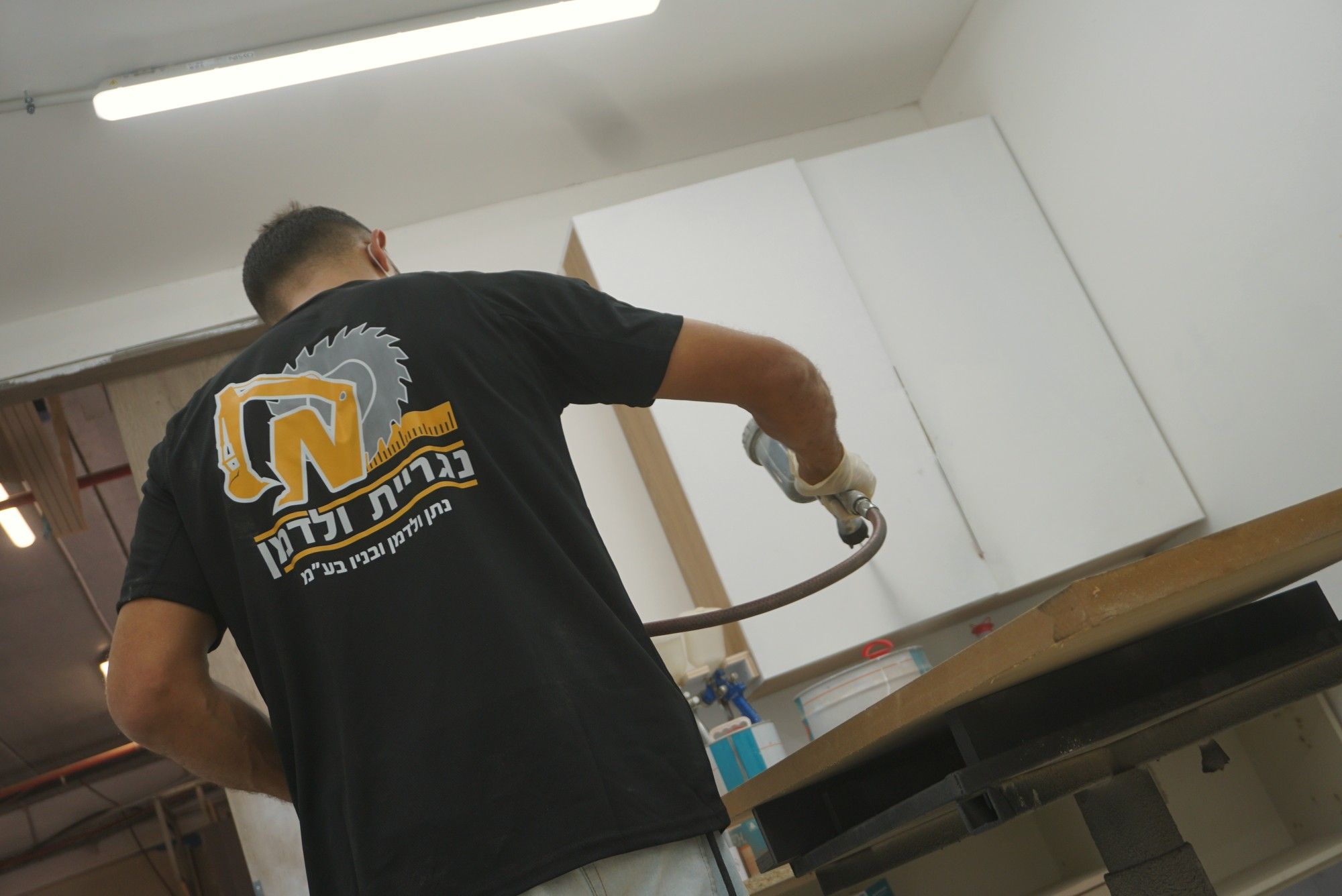 גב חולצת נגריית ולדמן בזמן ריסוס בתא הצבע